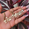 Gold name necklaces on a hand with a plant in the background