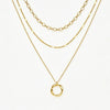 A layered gold necklace set featuring three distinct chain styles and a twisted oval pendant, displayed on a clean white background.