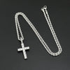 Silver chain necklace with a cross pendant on a dark background