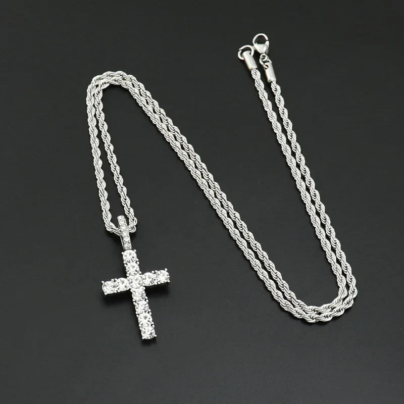 Silver chain necklace with a cross pendant on a dark background