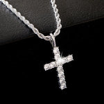Silver cross necklace with clear stones on a black background