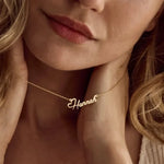 Close-up of a woman wearing a gold 'Hannah' necklace.