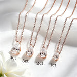 Four rose gold necklaces with pear-cut clear crystals are arranged diagonally on white satin fabric, with text labels indicating 4ct, 3ct, 2ct, and 1ct sizes.