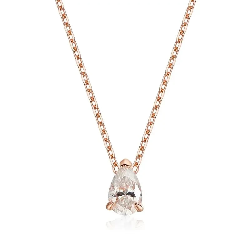 A pear-cut clear gemstone pendant necklace in a rose gold four-prong setting on a matching rose gold chain, shown against a plain white background.