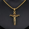 Gold crucifix pendant on a chain against a black background