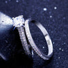 Silver ring with a large central gemstone and smaller stones on a dark background