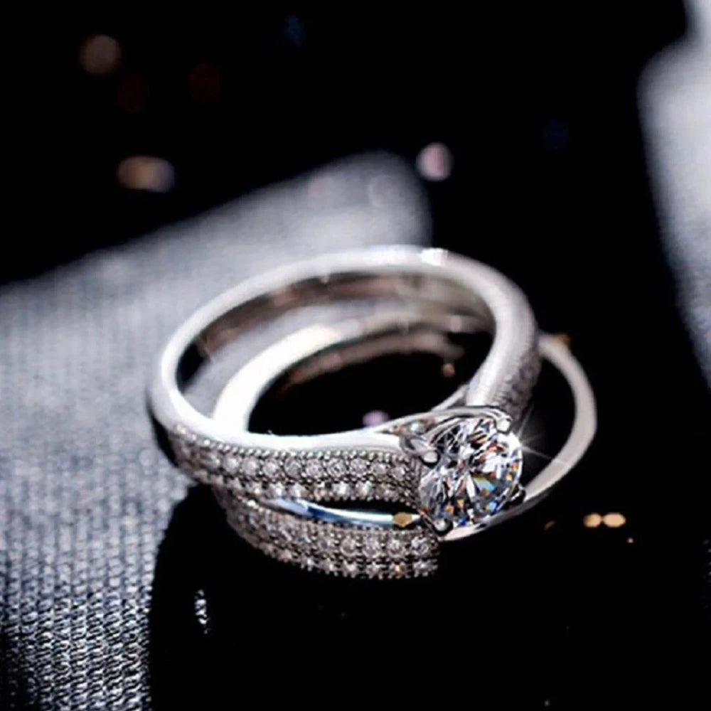 Silver ring with a diamond on a dark fabric background