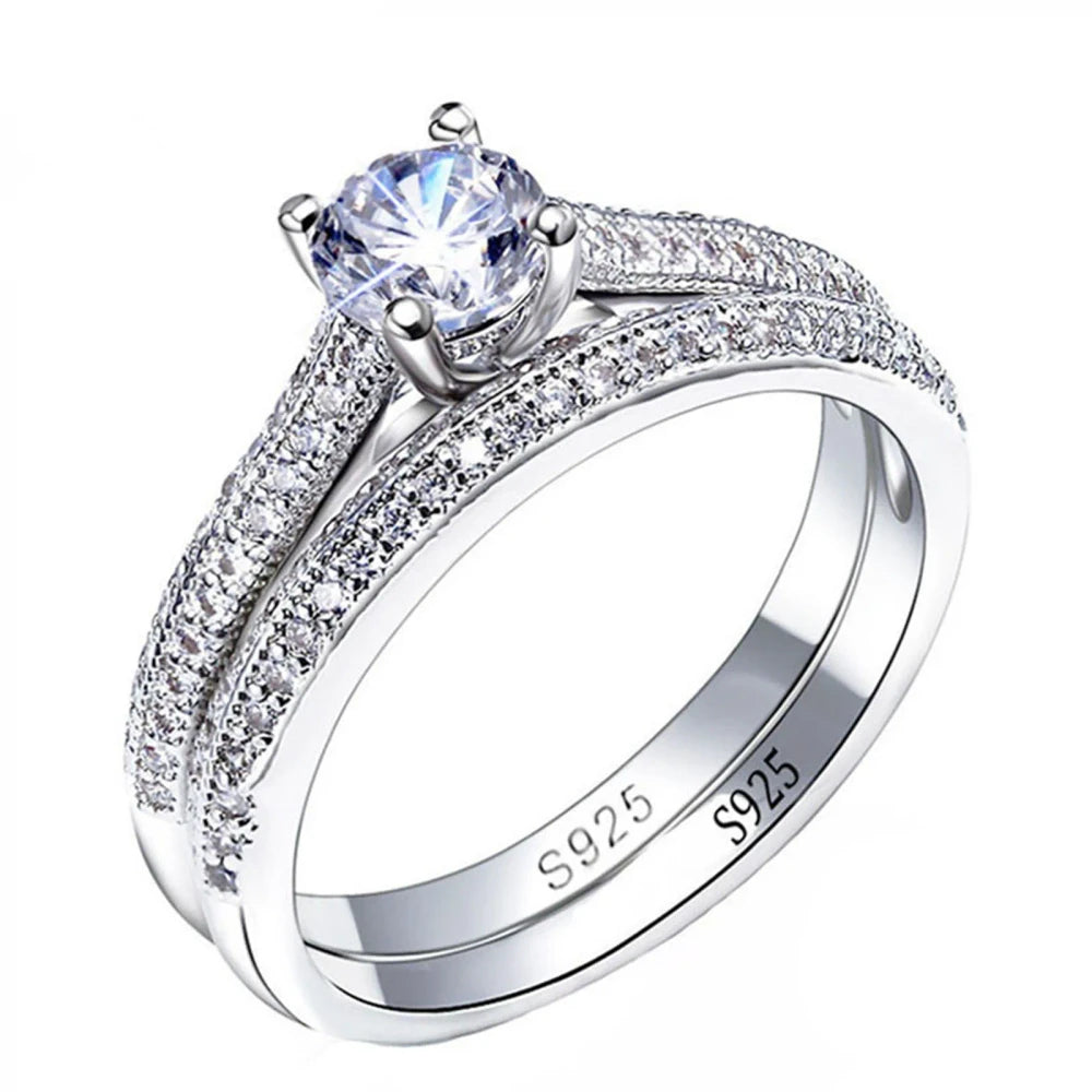 Silver ring with a large central gemstone and smaller stones on a white background