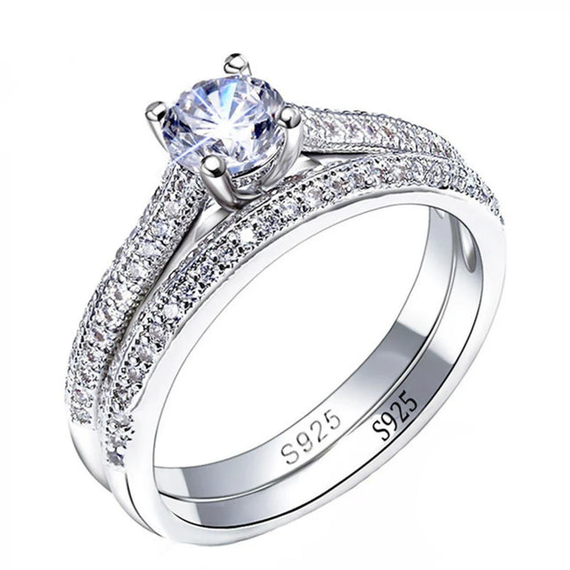 Silver ring with a large central gemstone and smaller stones on a white background